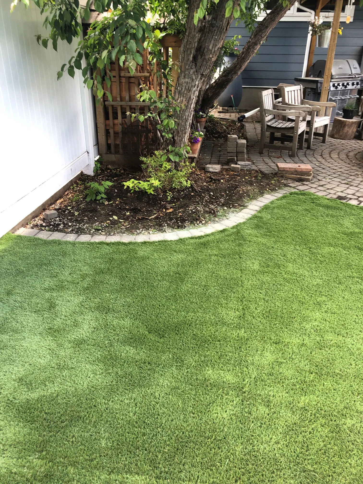 Beautiful artificial turf backyard with patio and landscaping